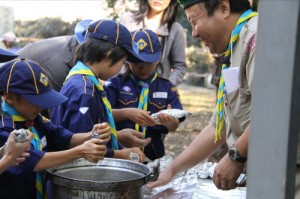 芋をくるんで焼き芋の準備